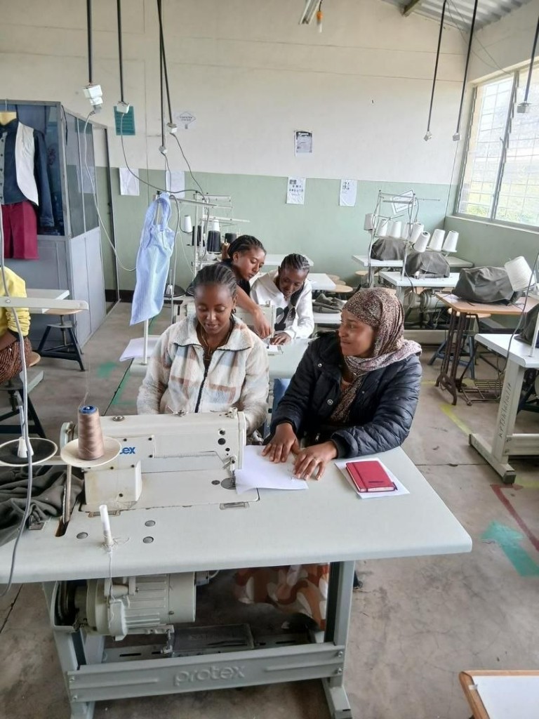 Peer learning and mentorship at every sewing station.